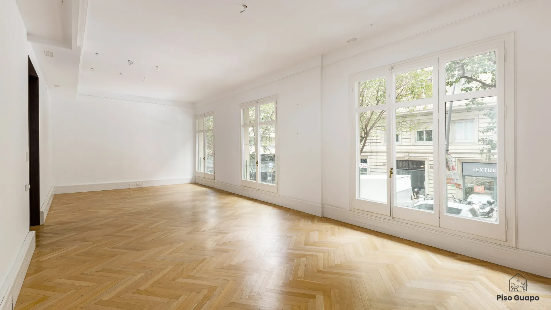 Fotografía inmobiliaria de salón diáfano con luz natural en Barcelona