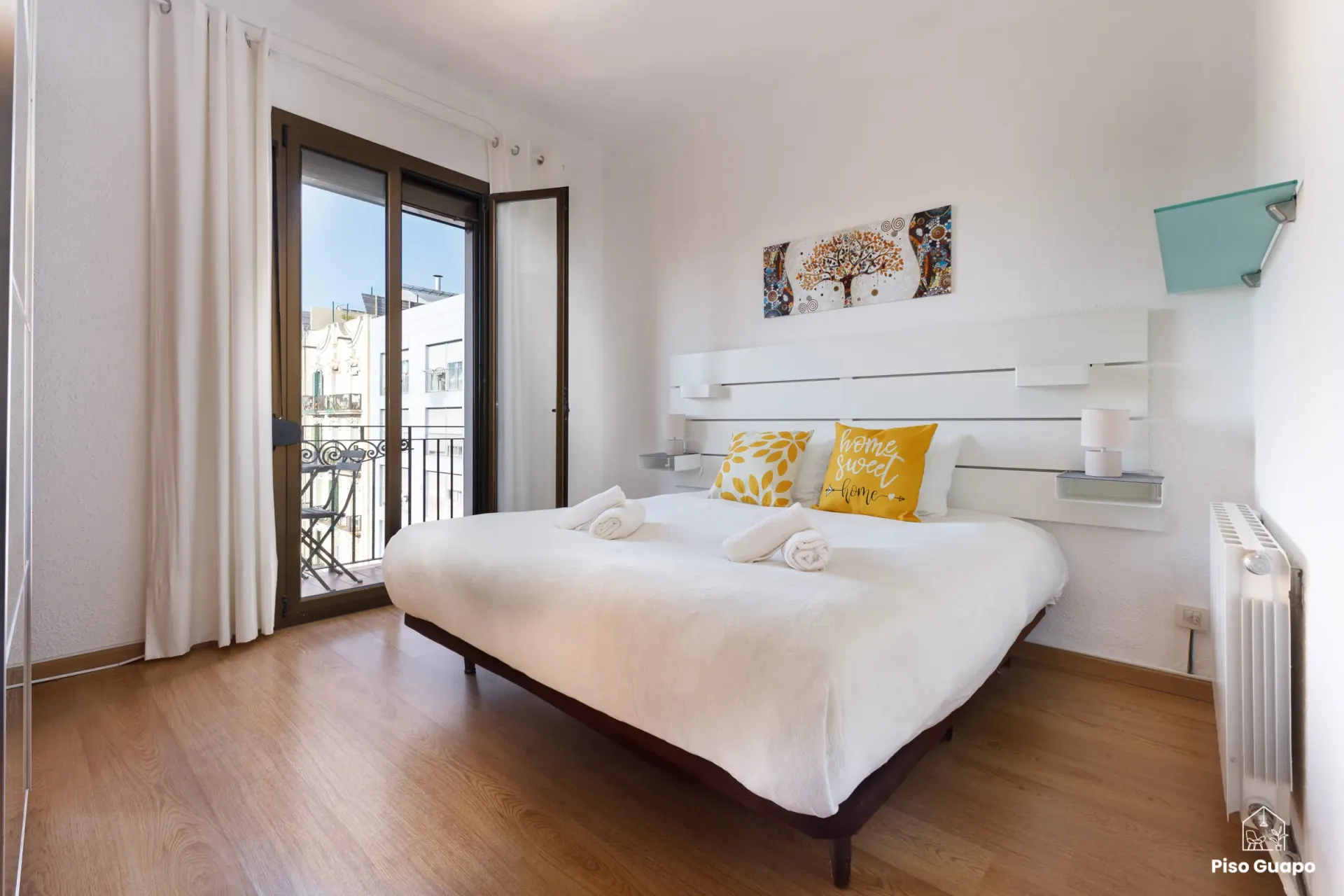 Fotografía inmobiliaria de dormitorio principal con balcón en Barcelona