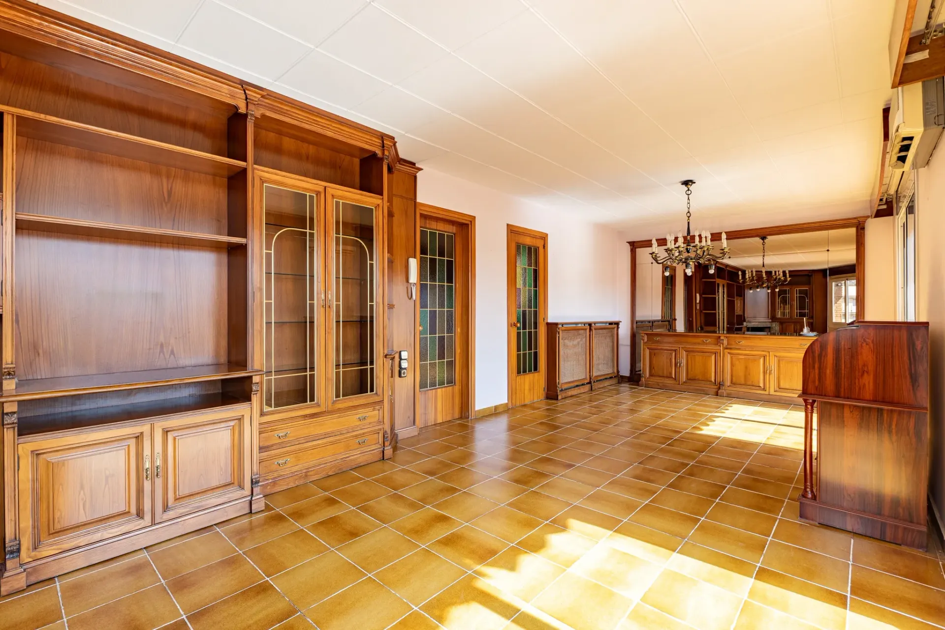 Fotografía inmobiliaria de salón clásico con muebles de madera y suelo cerámico