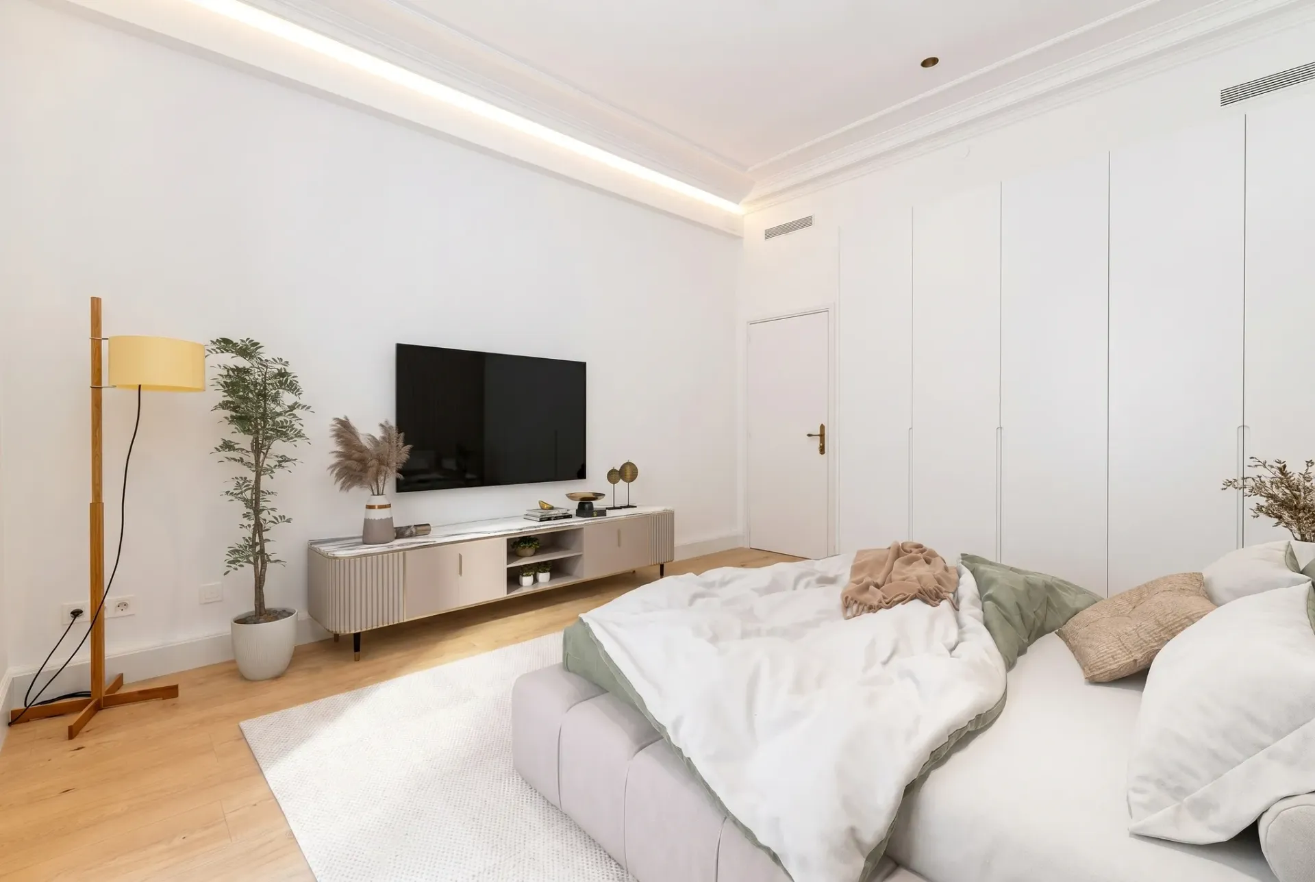 Render inmobiliario de dormitorio moderno con televisión mural y armarios empotrados