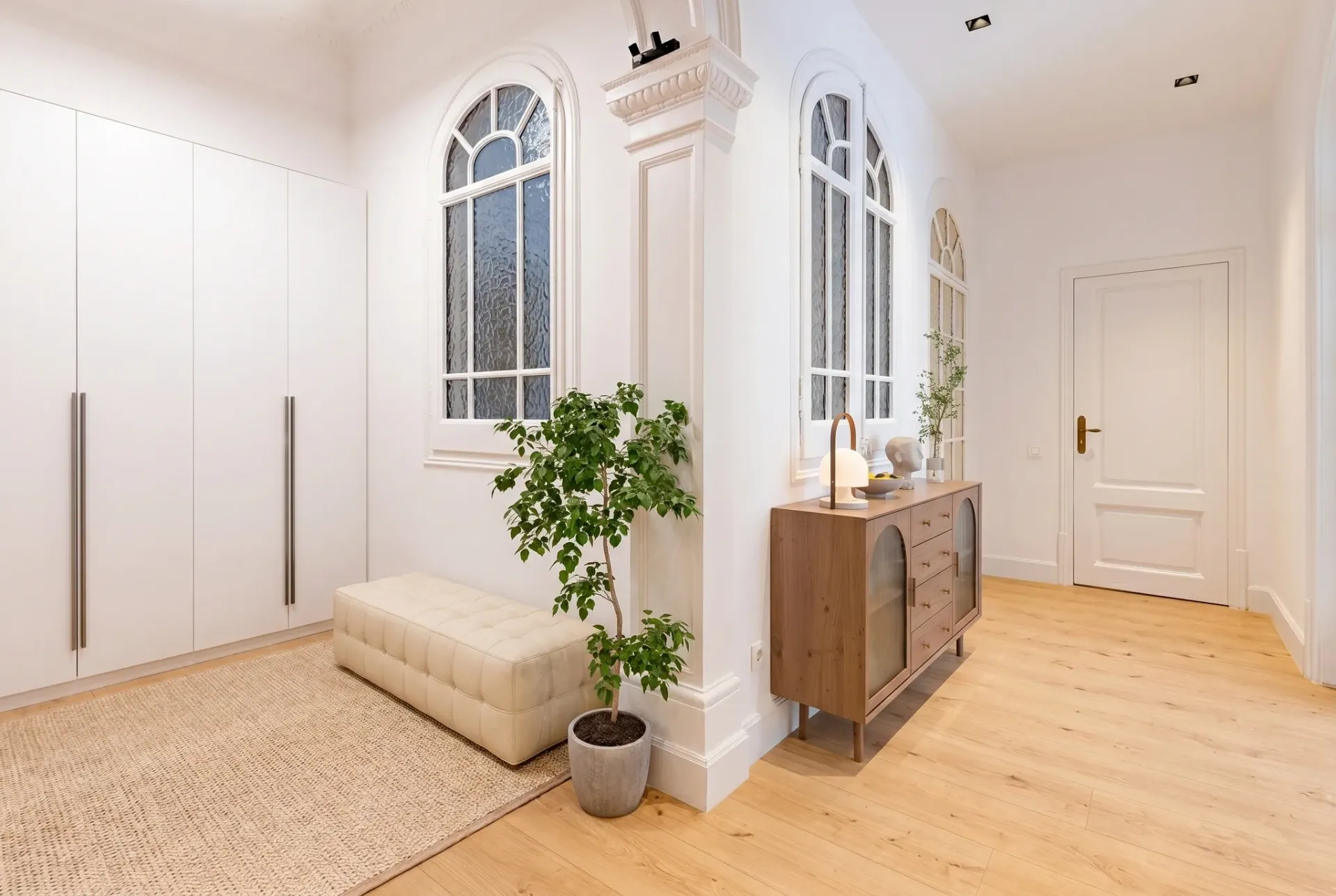 Render inmobiliario de vestidor luminoso con armario empotrado y banco tapizado