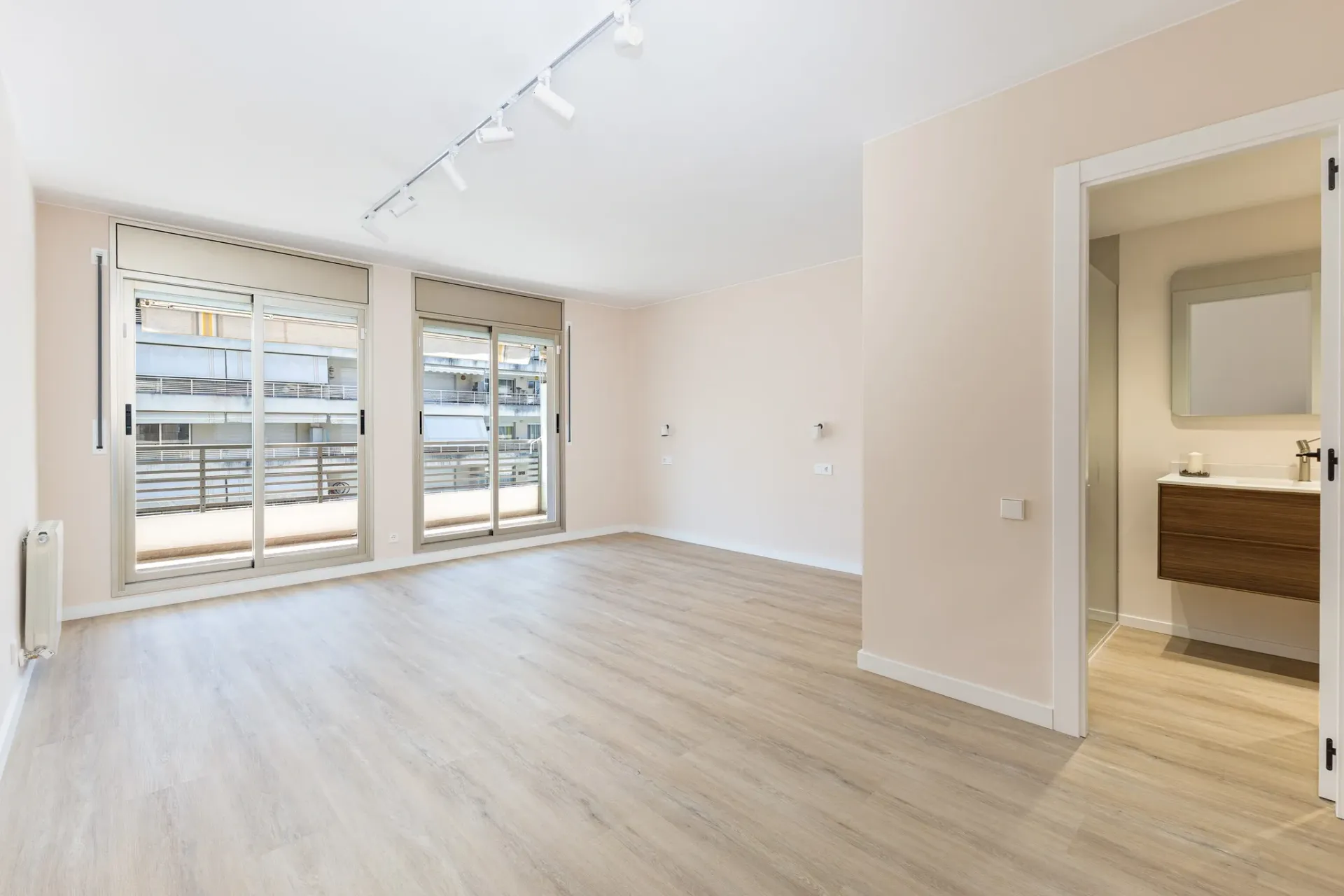 Salón luminoso de piso reformado con salida a terraza y baño en suite, fotografiado para vídeo inmobiliario profesional de Piso Guapo.