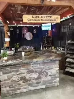 Concrete countertop display booth with stone facade and signage,