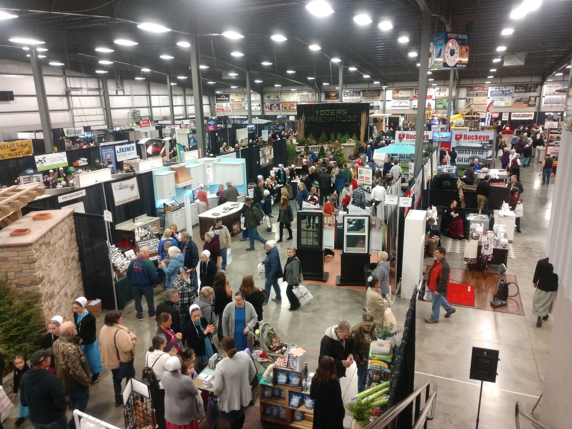 Large indoor trade show; booths, many people browsing and walking.