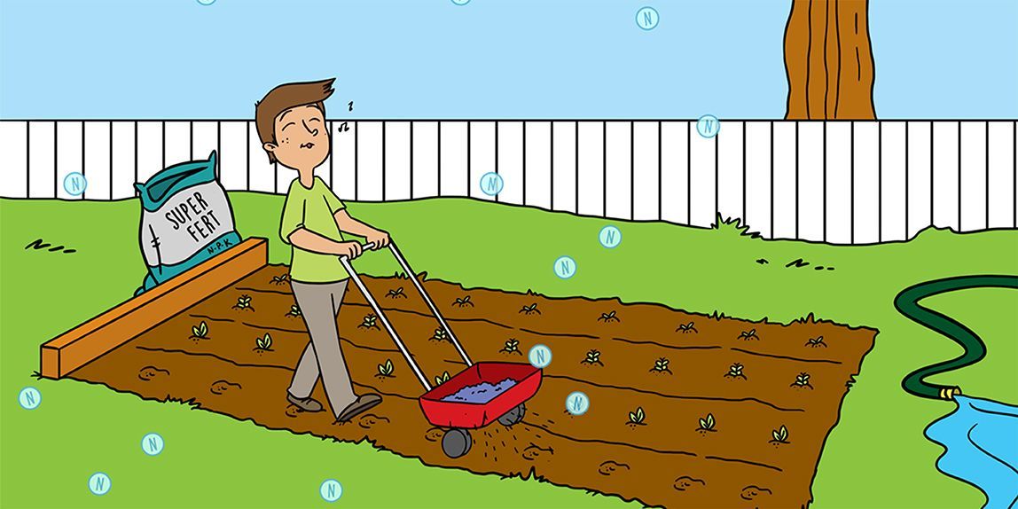 Person raking leaves in a backyard, with a wheelbarrow, fence, tree, and pond nearby.