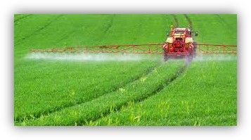 Tractor spraying water over a lush green field