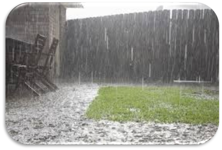 Rainstorm over backyard patio and lawn, with heavy rain and wet ground, green grass patch visible.