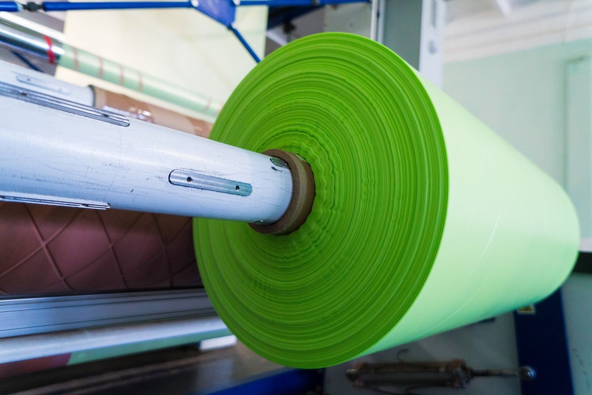 Green paper roll on a manufacturing machine in a factory