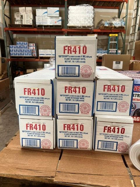 Black plastic trash bag roll partially unrolled on a white background