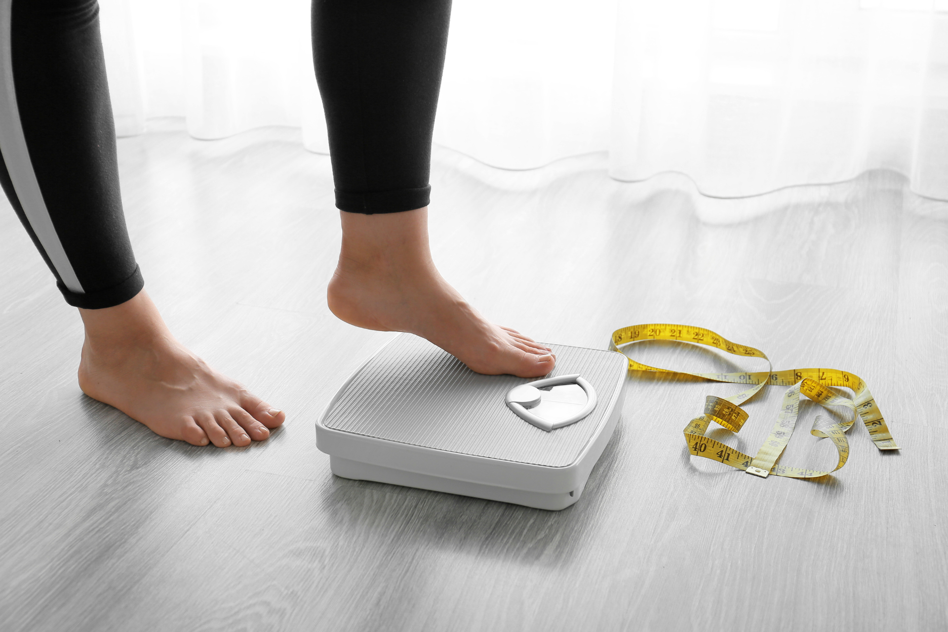 a girl looking at her weight using a weighing scale