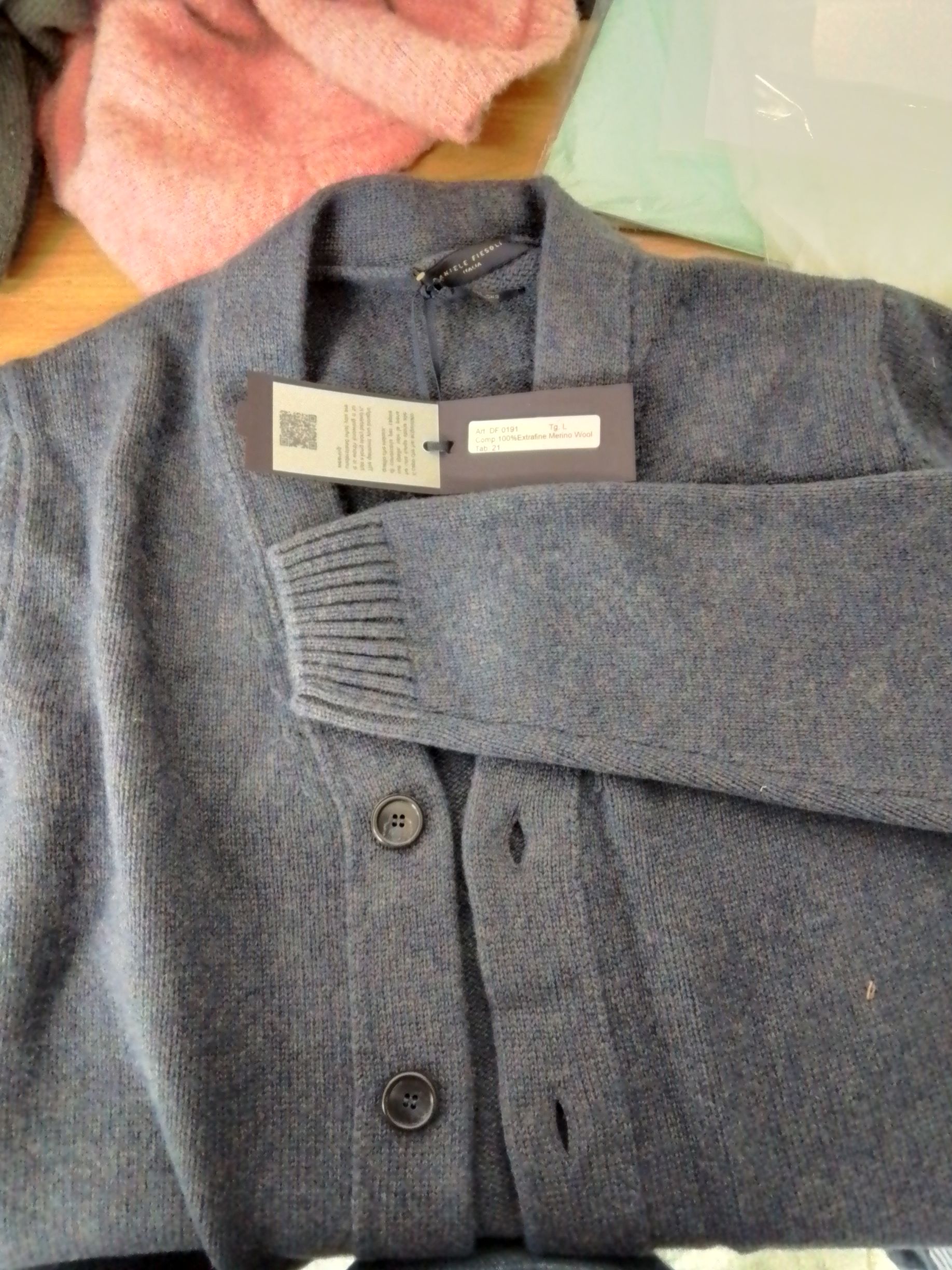 Cardigan grigio con tre bottoni e etichetta attaccata.