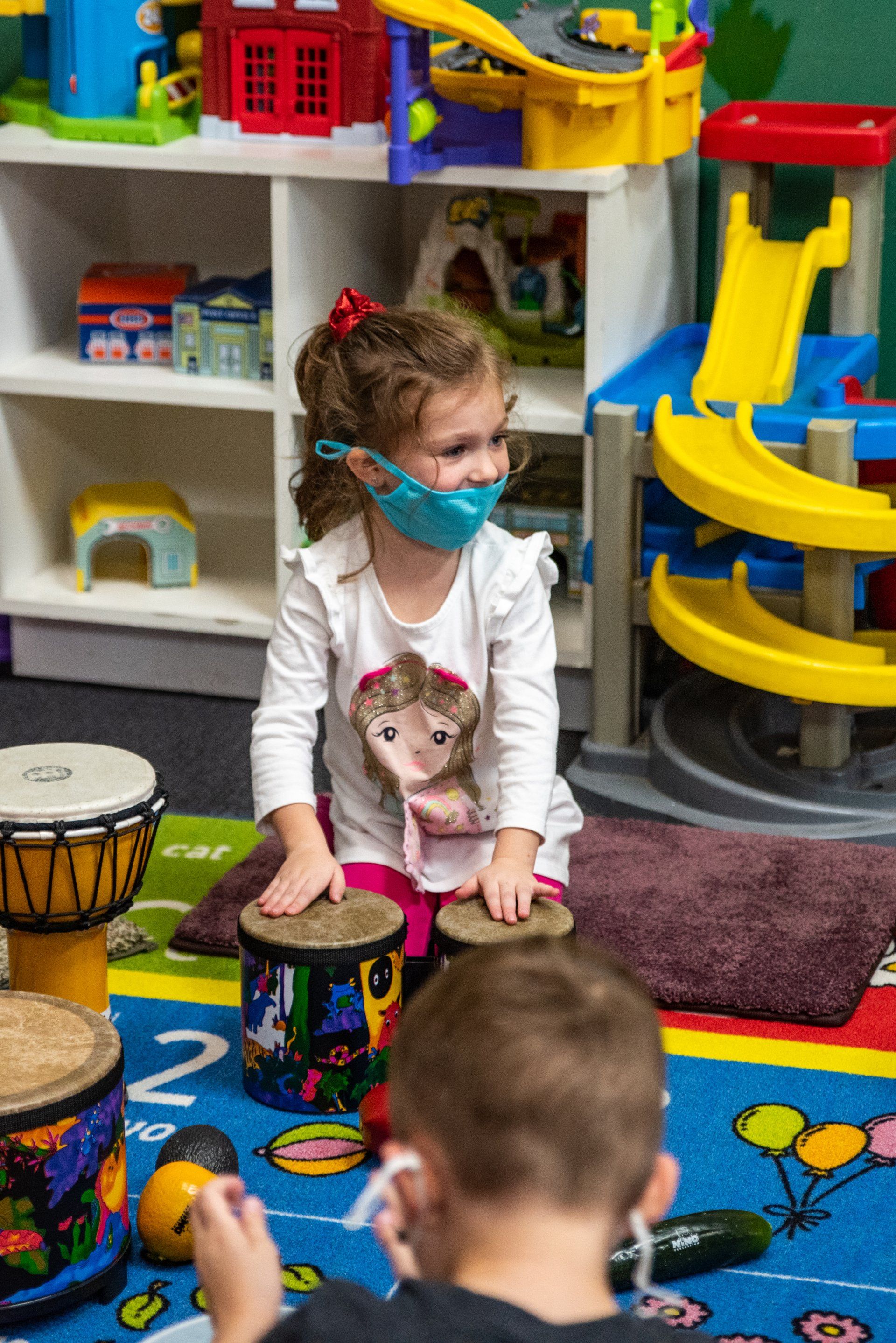 young girl playing the drums during an exercise at school