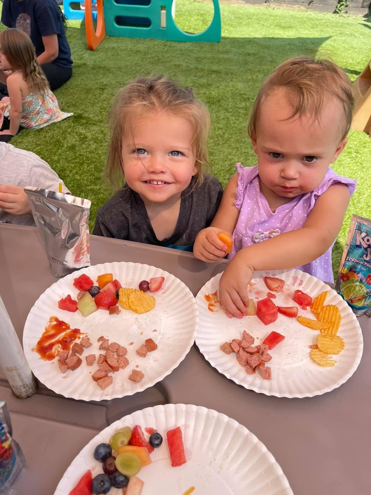 two young girls eating healthy snack at daycare center