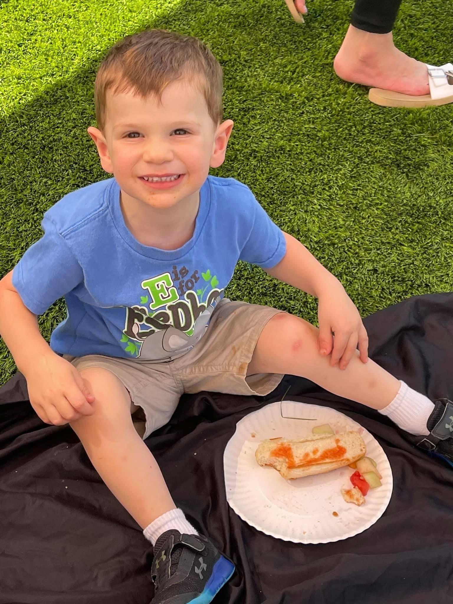 young boy eating snack at preschool