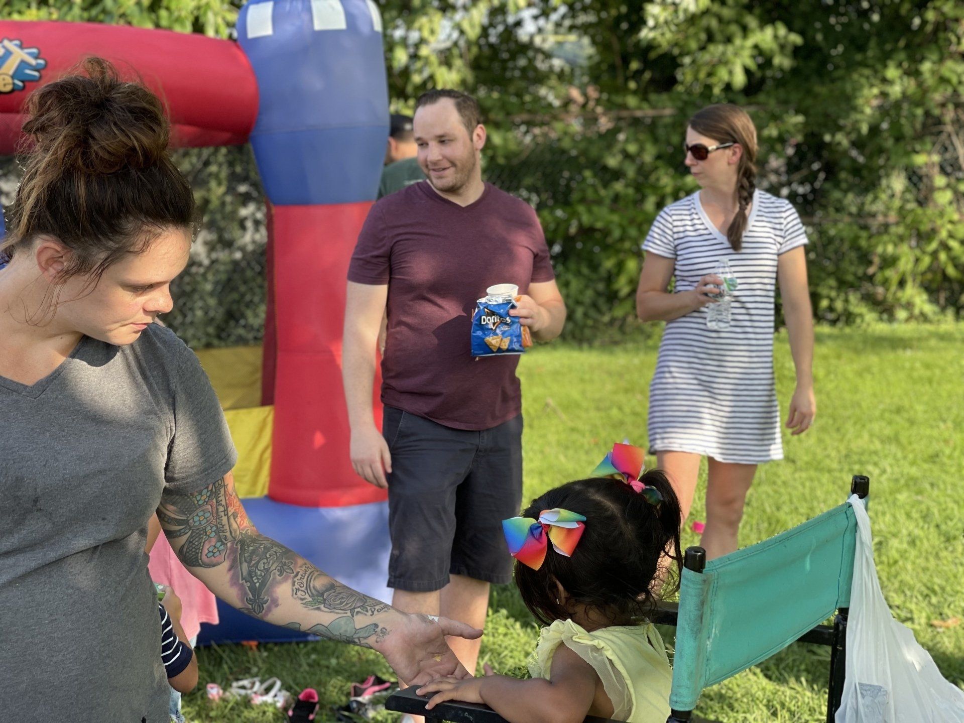 teachers and parents at preschool event outside with bounce house