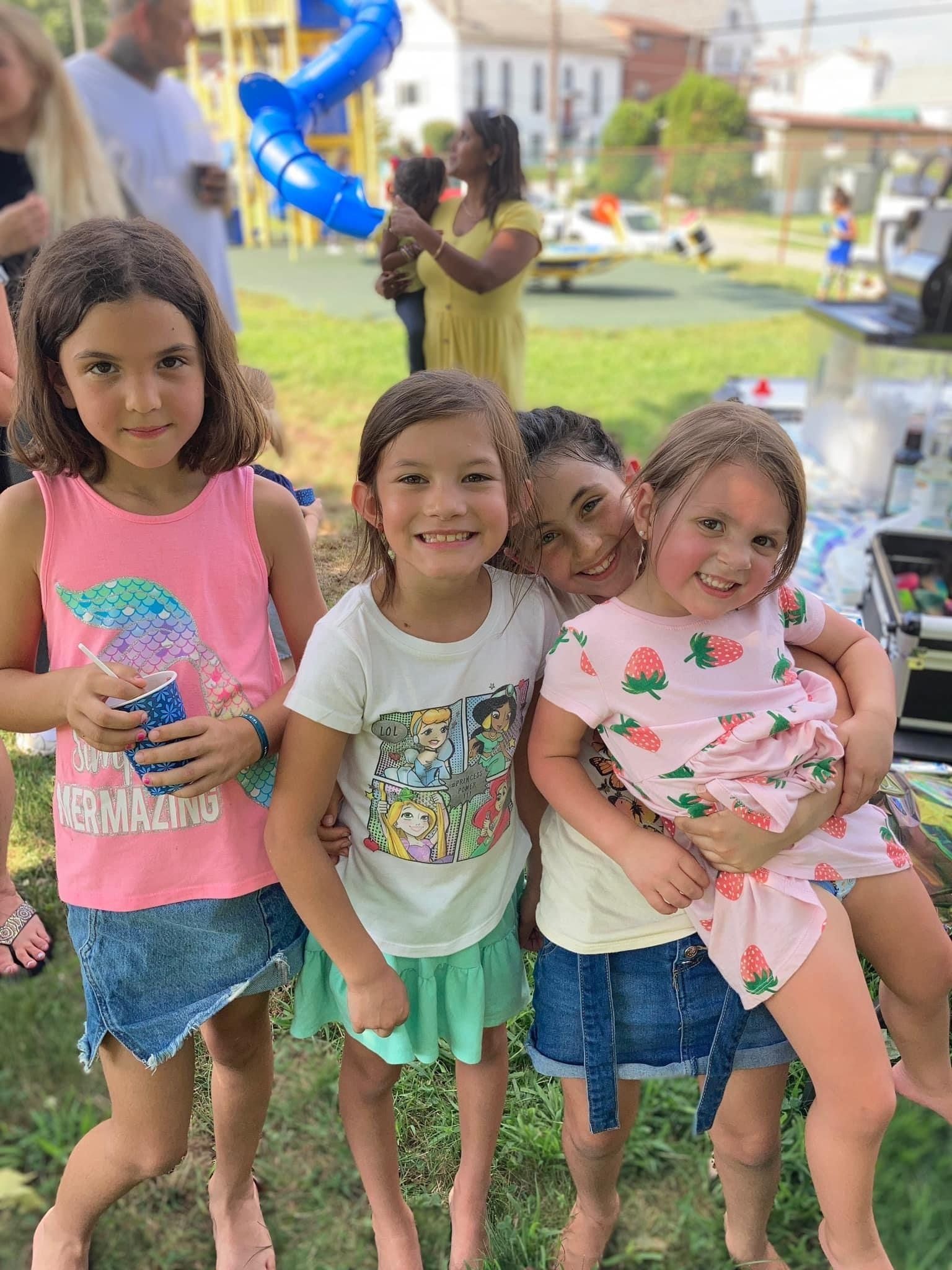 four young girls posing for a photo during preschool event
