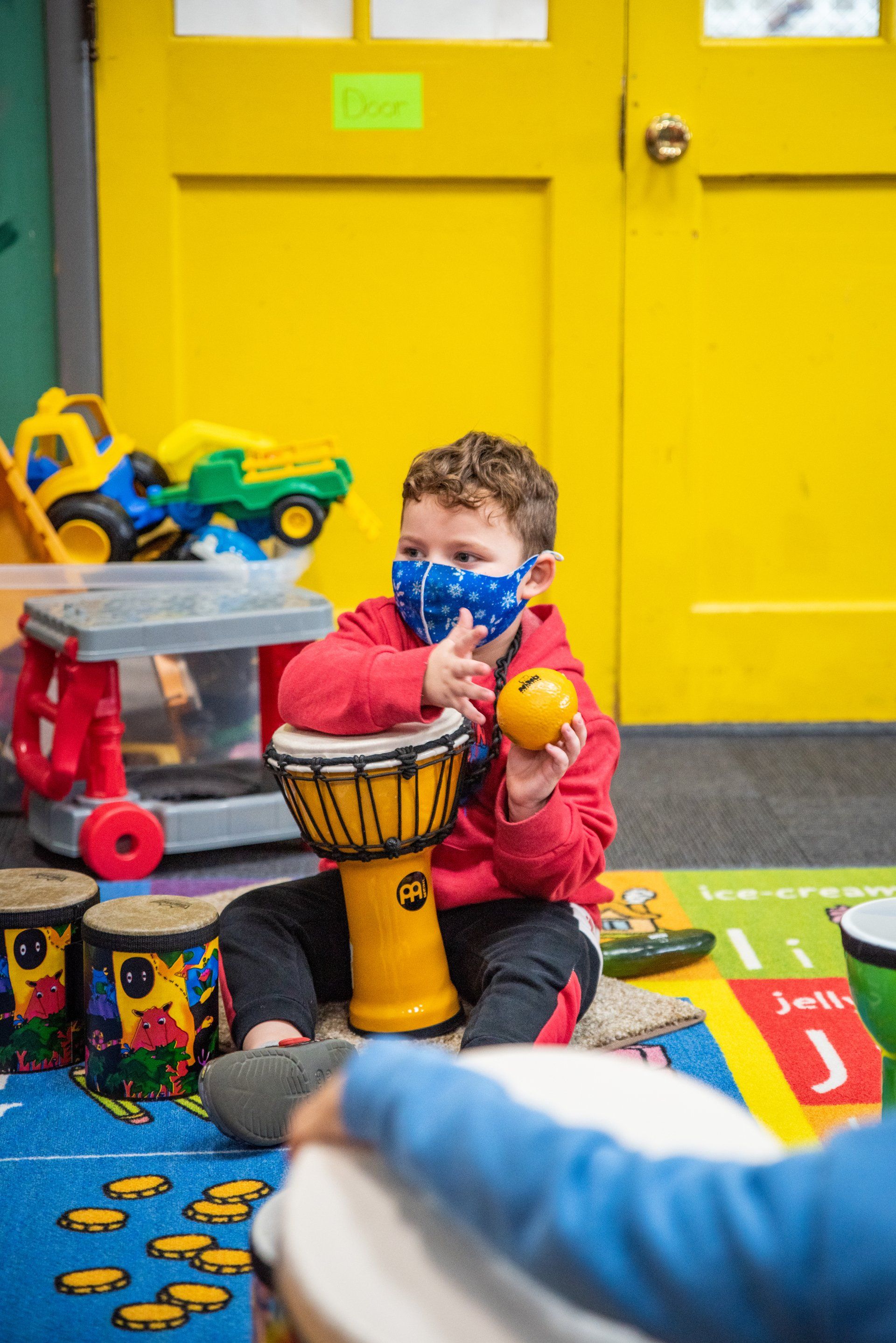 young boy playing with drums and a ball
