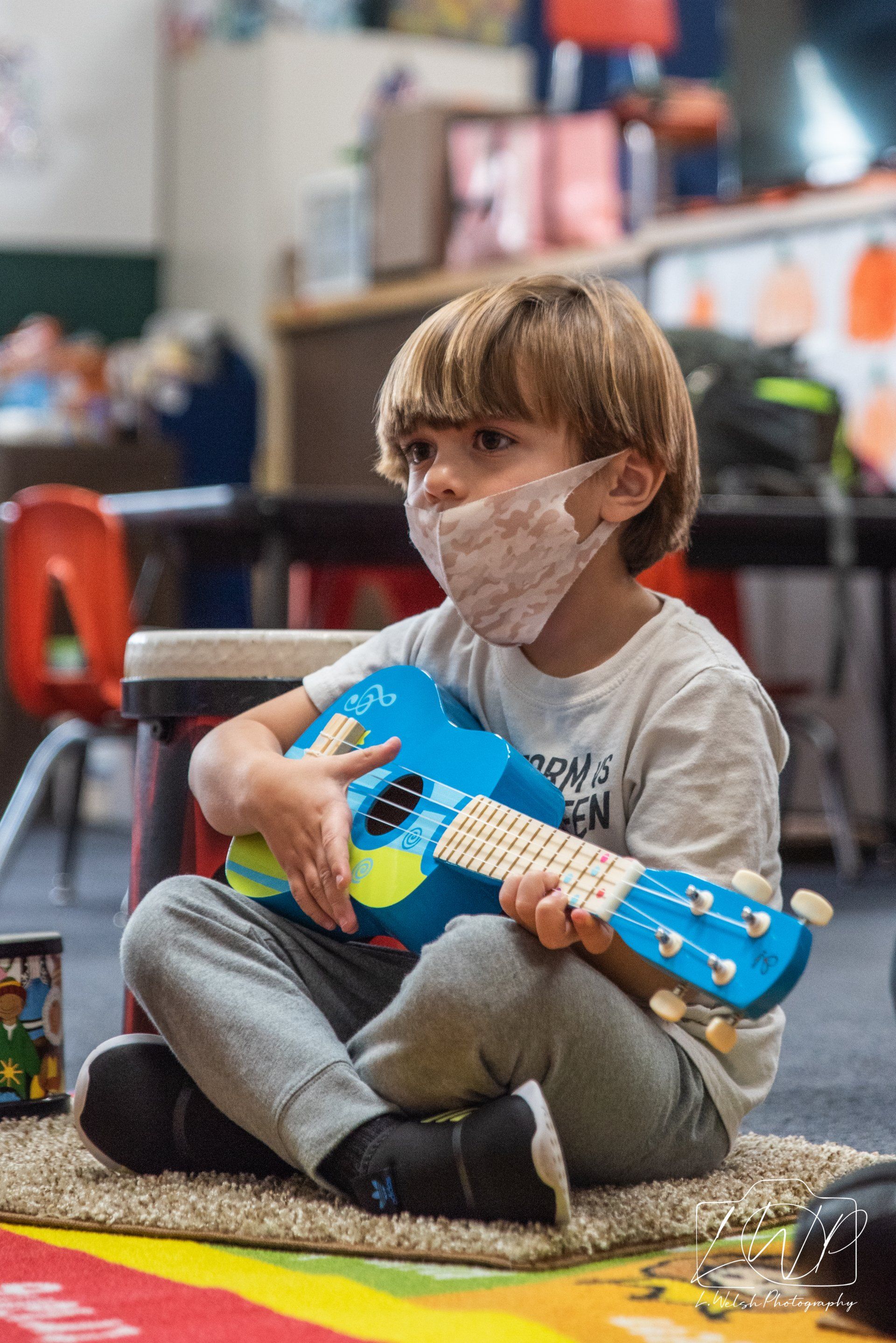 little kid playing a guitar