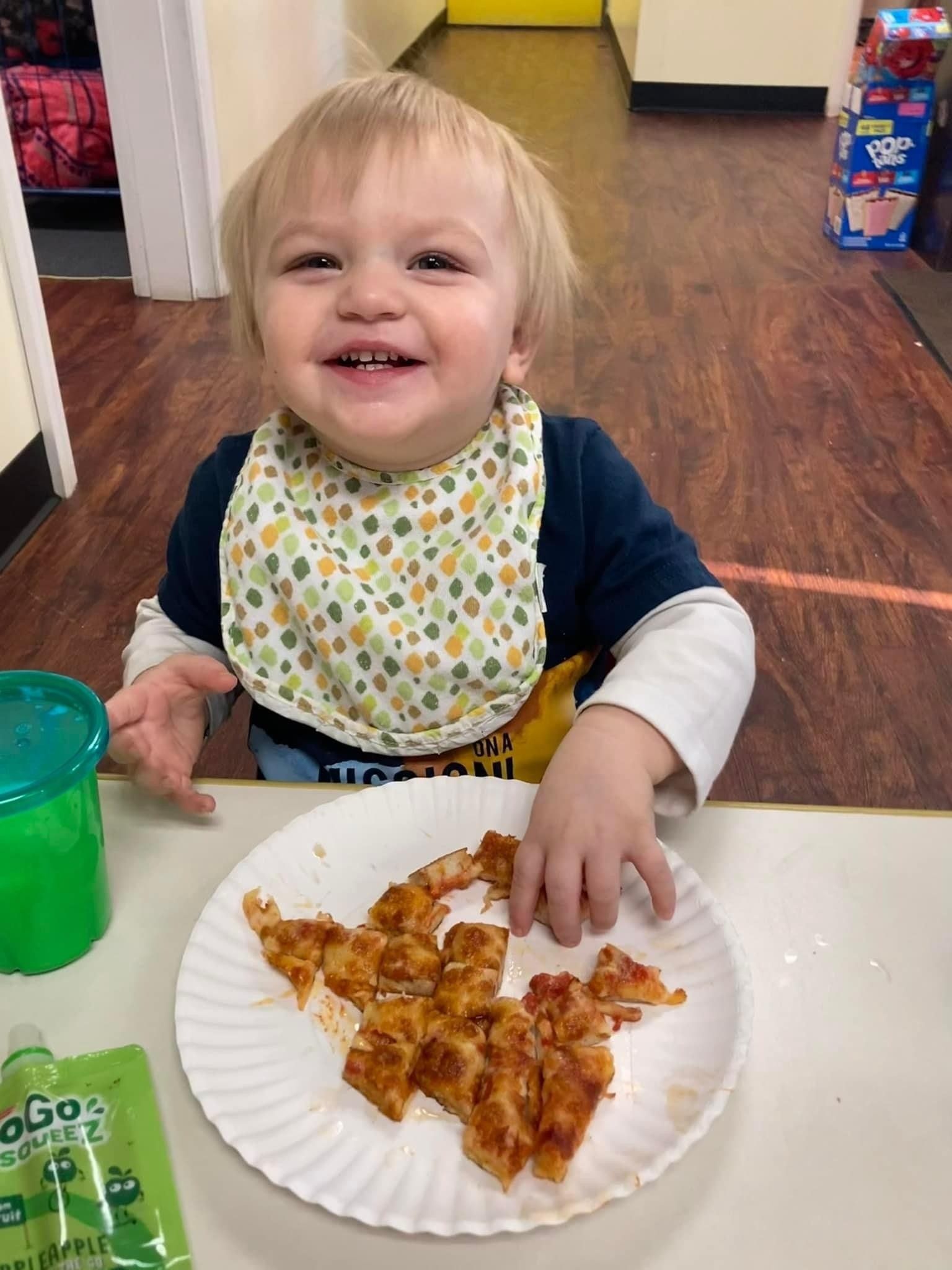 little kid eating snack at preschool