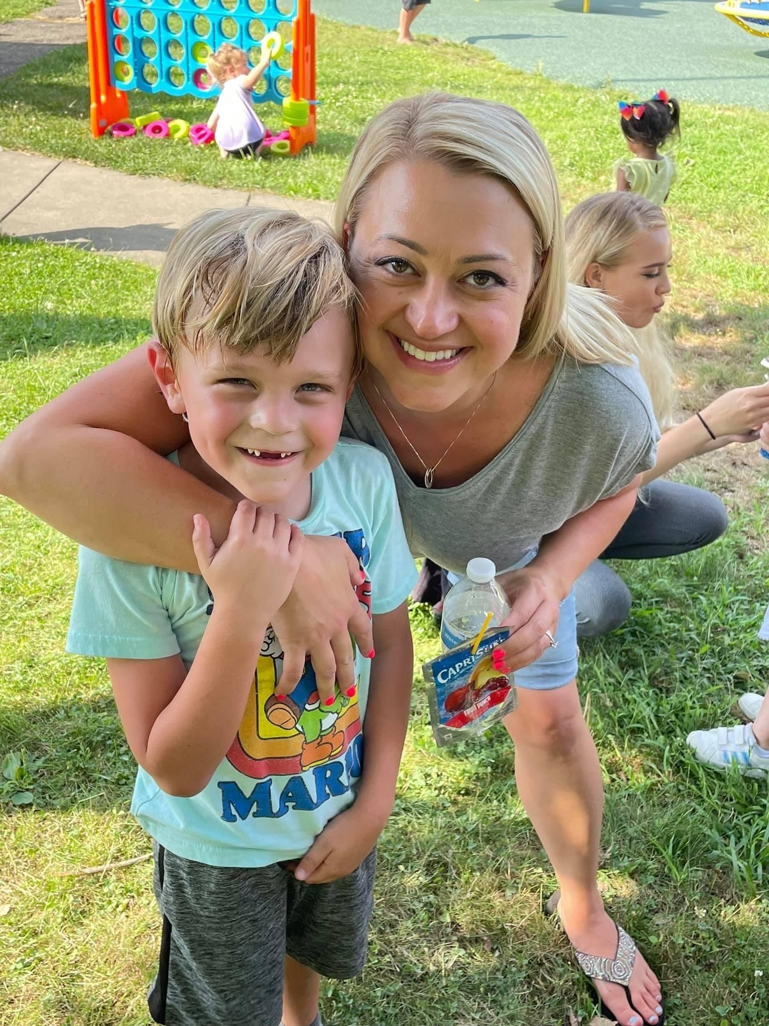 child and teacher with parent at outdoor schoole vent
