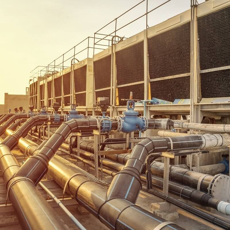 Industrial pipes and valves at a utility facility in warm sunset light