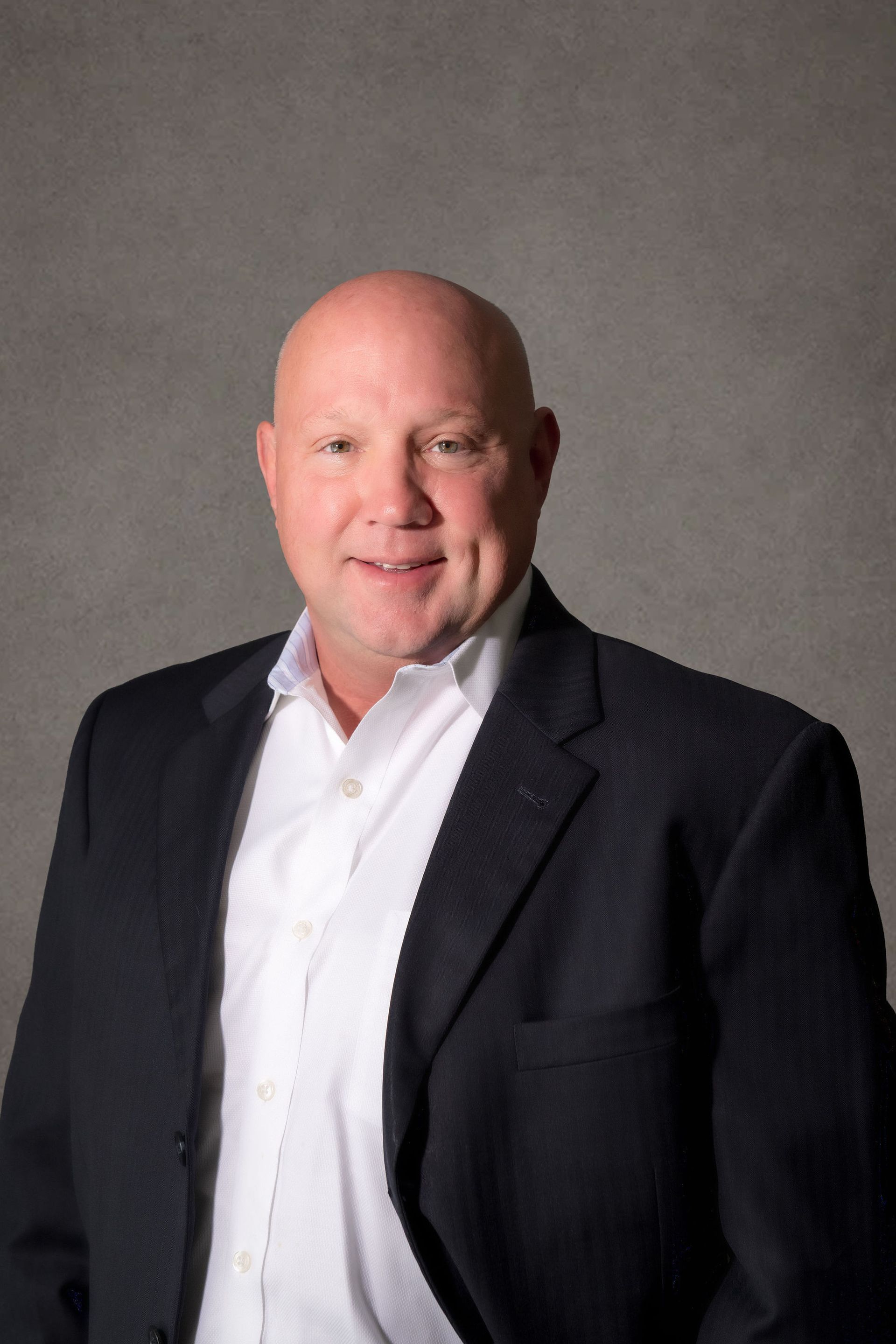 Professional headshot of Brian Demidovich, managing attorney, a smiling man in a suit in front of a gray background.