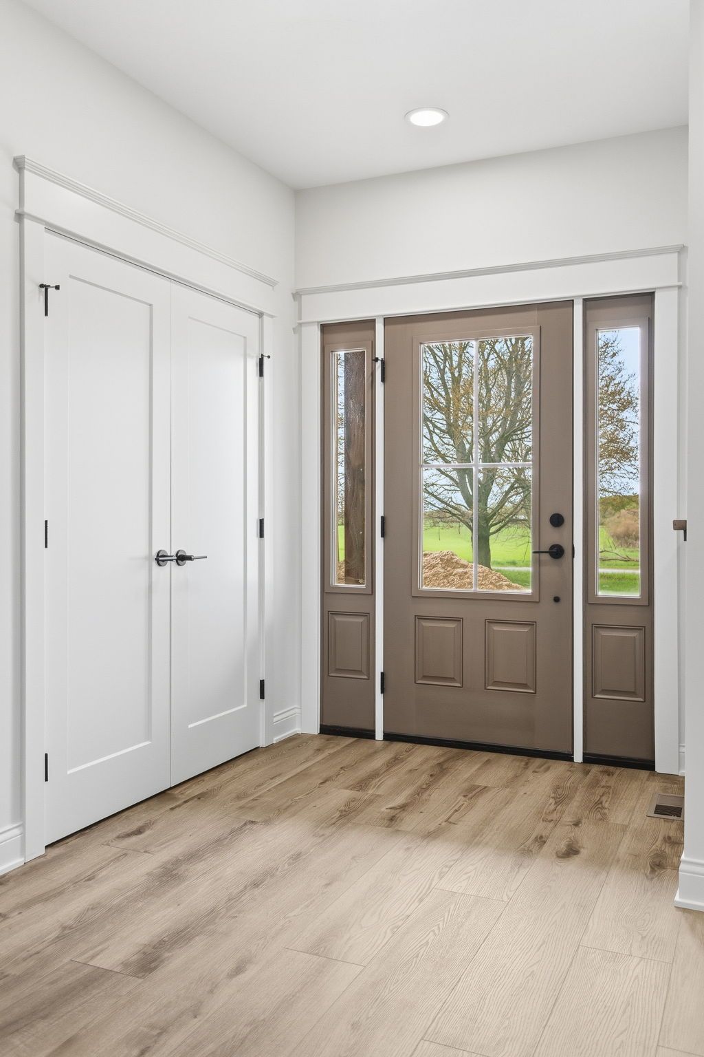 A walk-in closet featuring white wooden shelving and hanging rods on two adjacent walls, set against neutral walls.