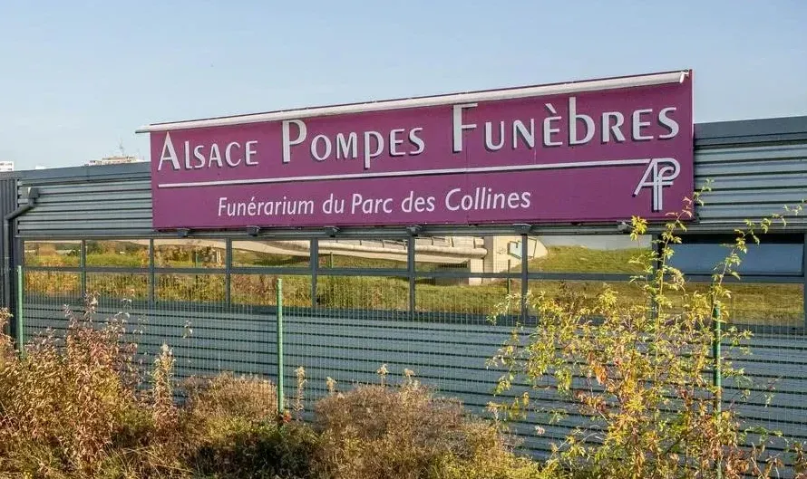 Alsace Pompes Funèbres Un panneau sur lequel est écrit Alsace Pompes Funèbres