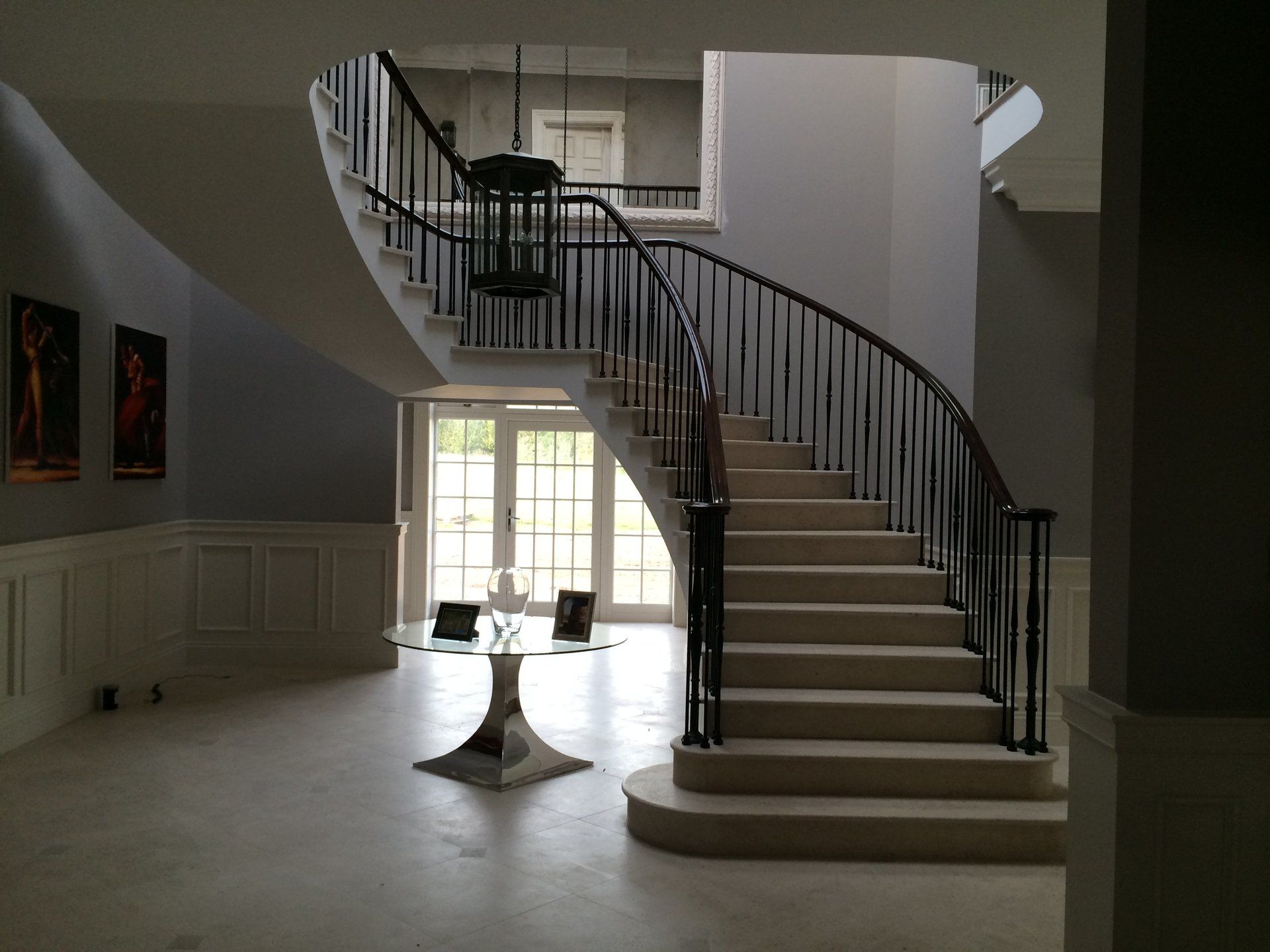 A curved staircase in a house with a table in the middle