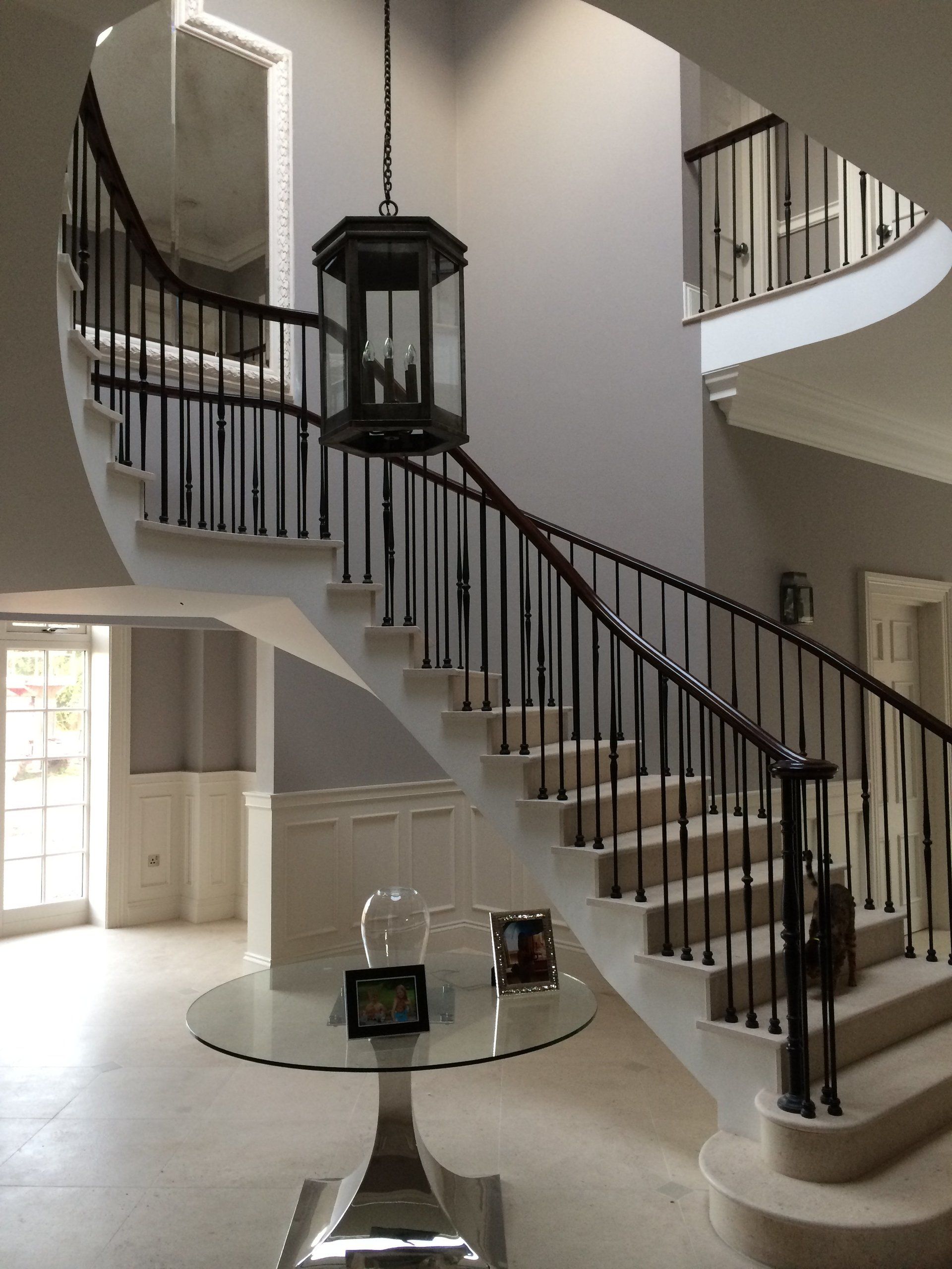 A curved staircase with a lantern hanging from the ceiling