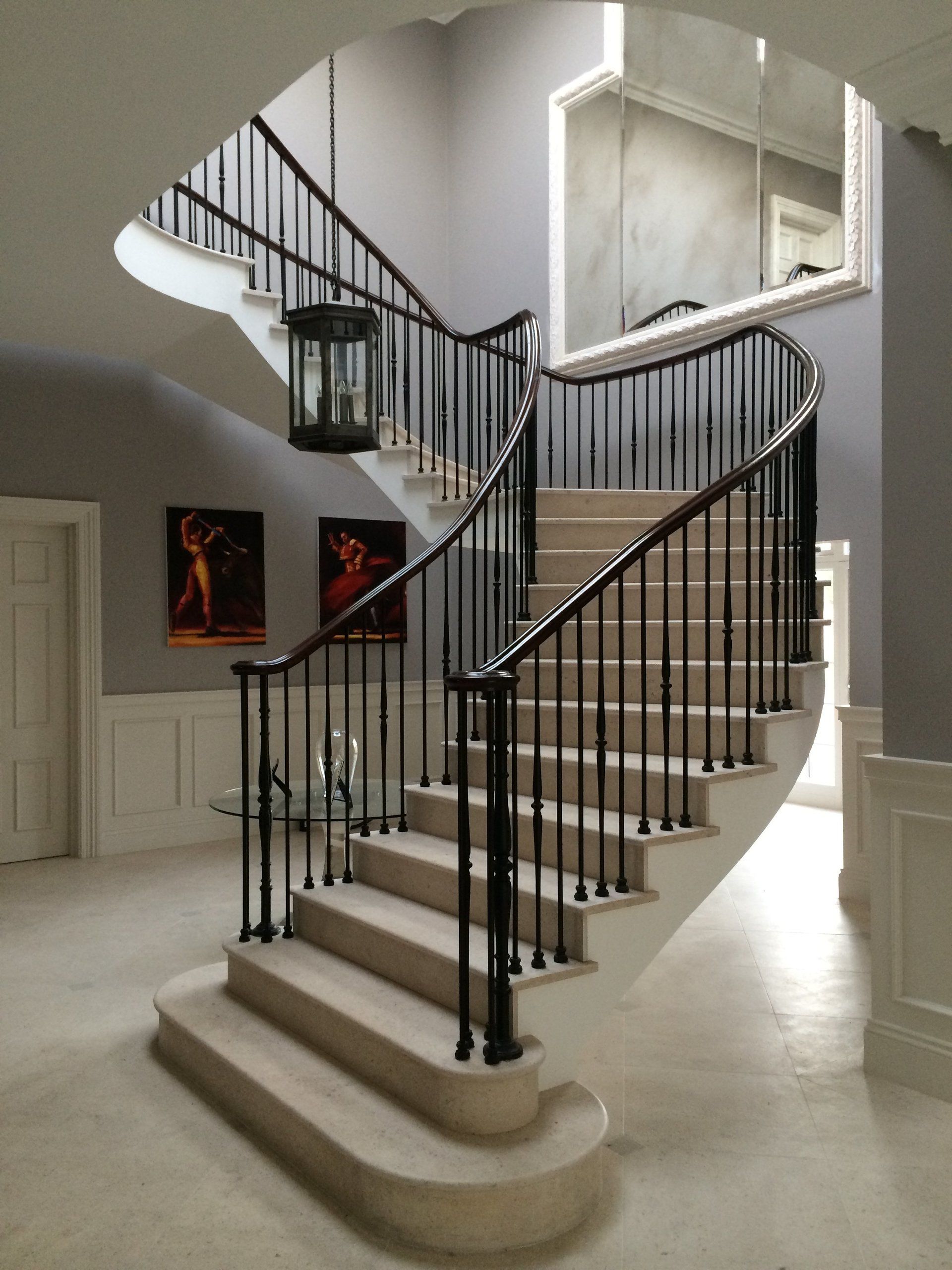 A curved staircase with a lantern hanging from the railing