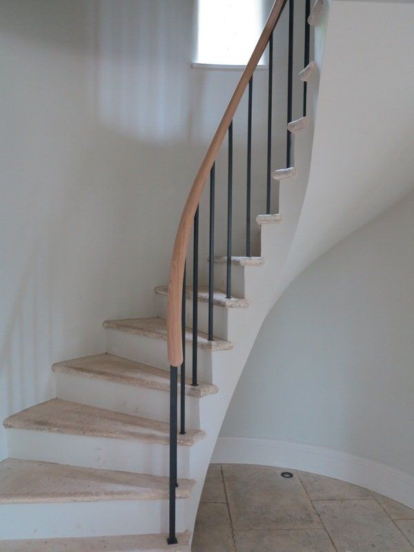 A white spiral staircase with a wooden railing