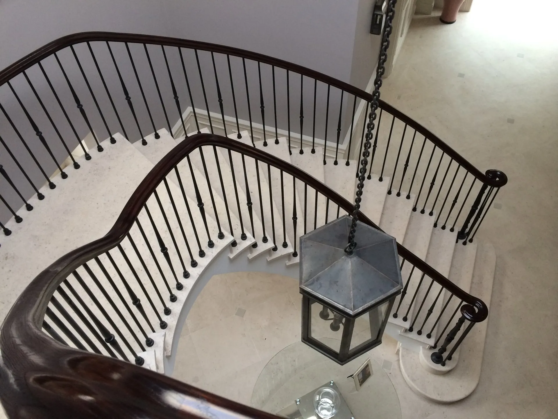 A curved staircase with a lantern hanging from the railing