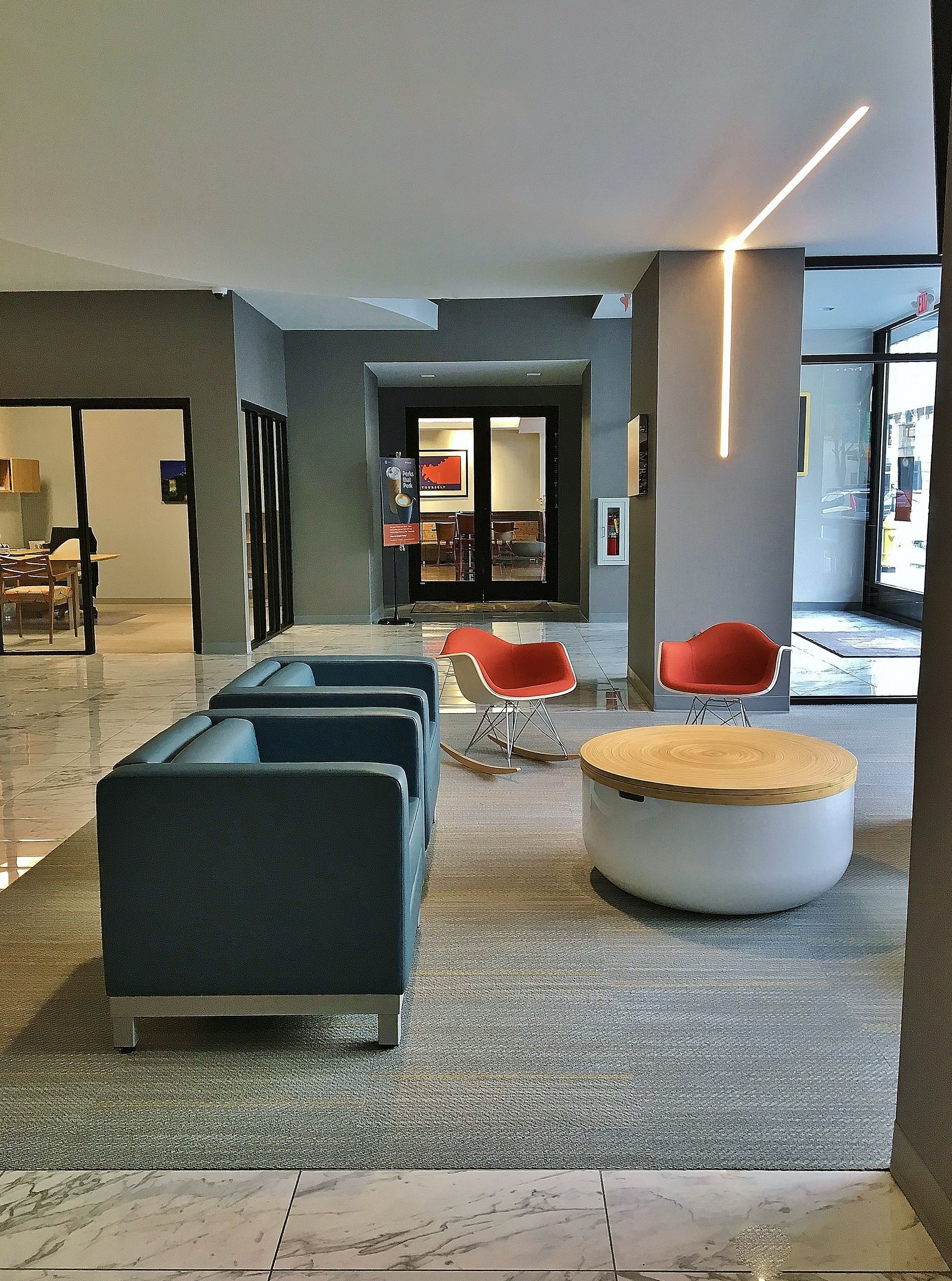A lobby with blue chairs and red chairs