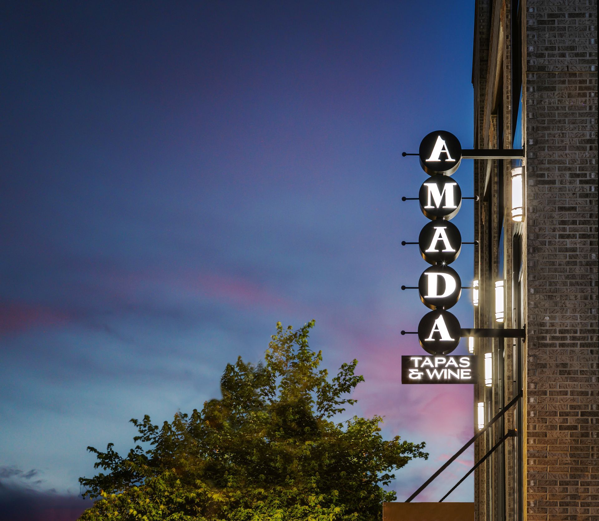 A sign on the side of a building that says ' armada tapas & wine '