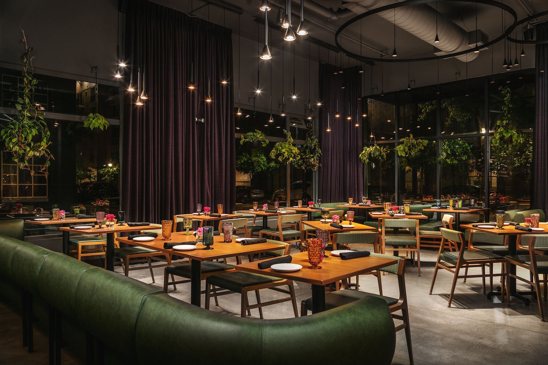 A restaurant with tables and chairs and a green couch.