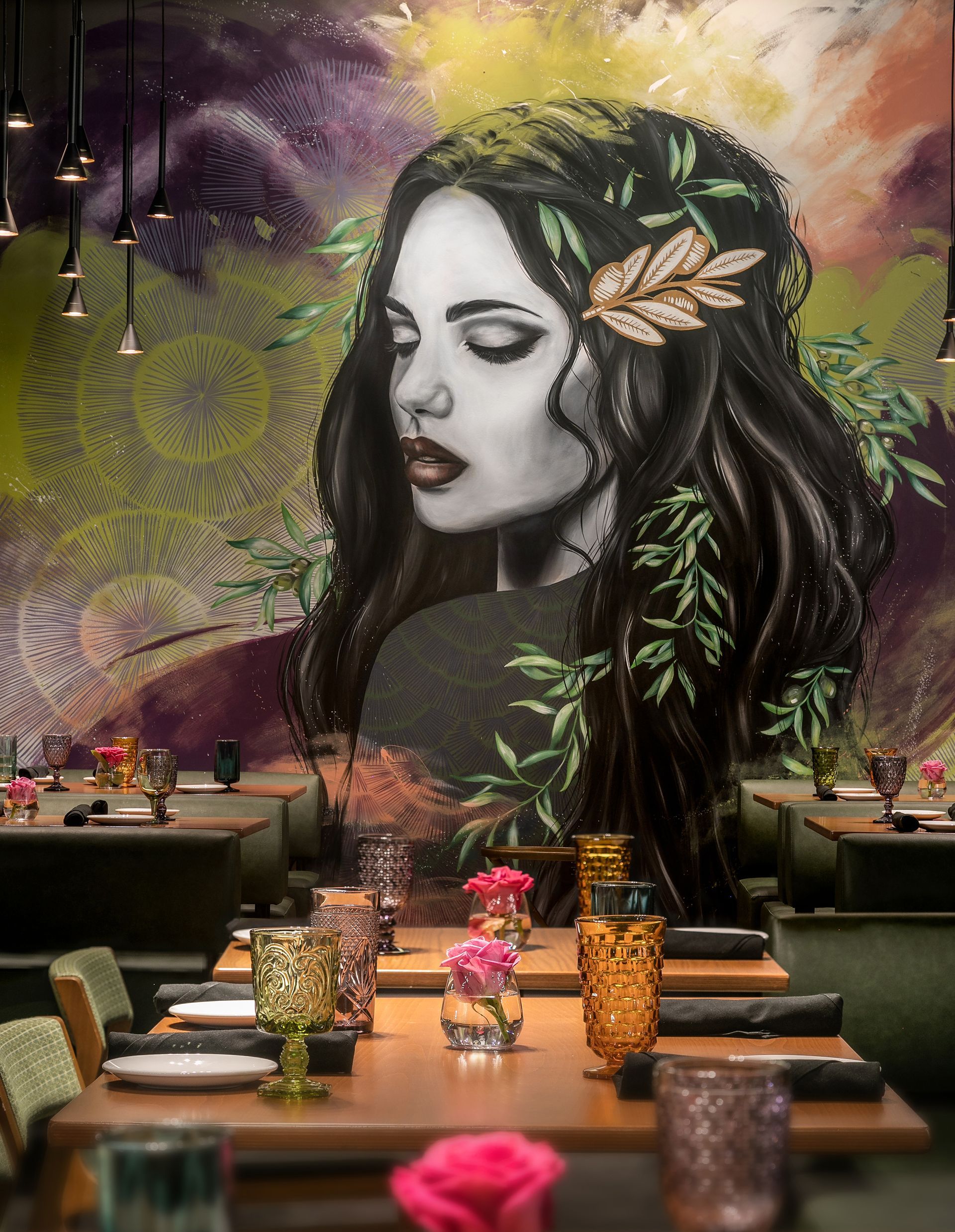 A restaurant with tables and chairs and a painting of a woman on the wall.