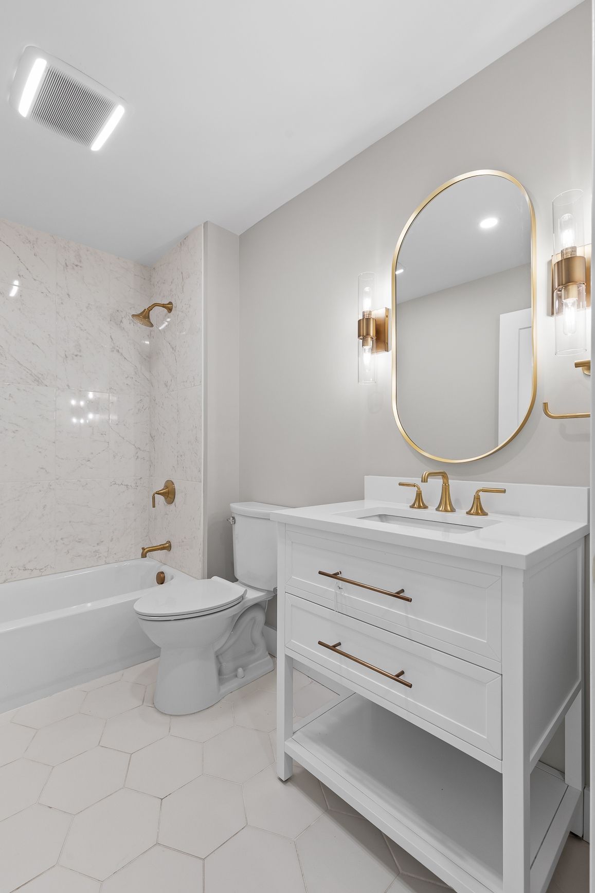 A bathroom with a sink , toilet , bathtub and mirror.
