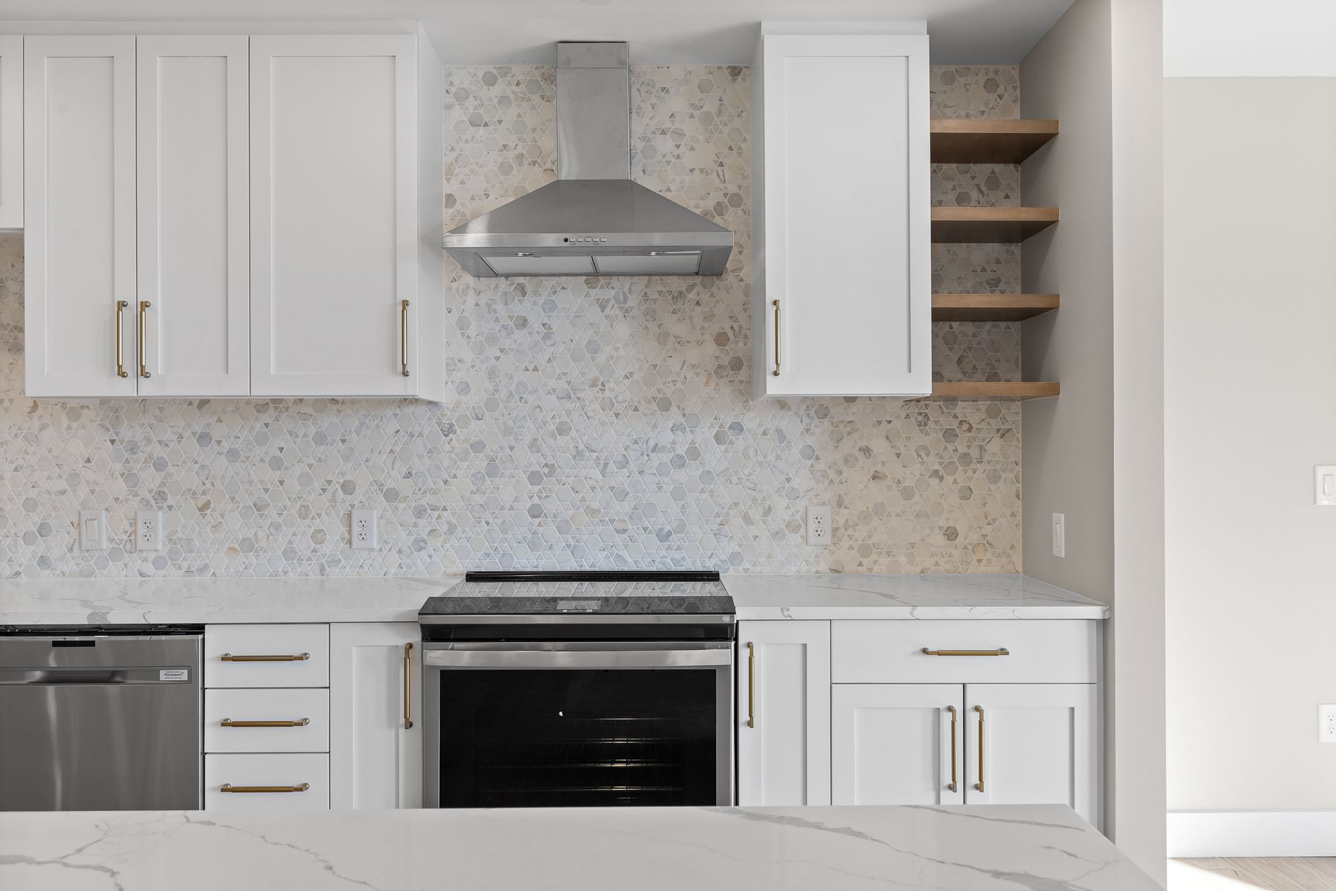 A kitchen with white cabinets , stainless steel appliances , and a stove.