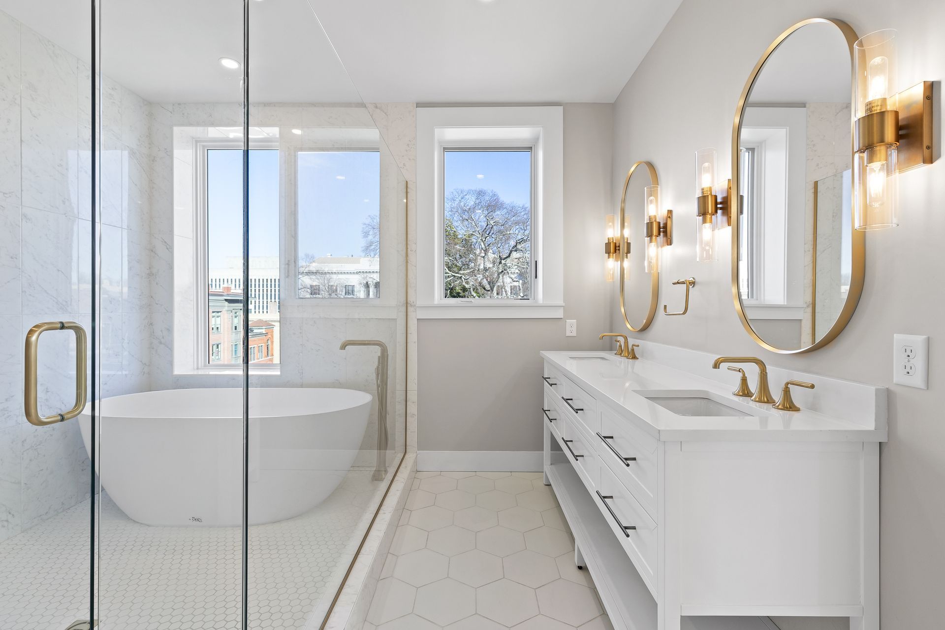 A bathroom with a tub , sinks , mirrors and a walk in shower.
