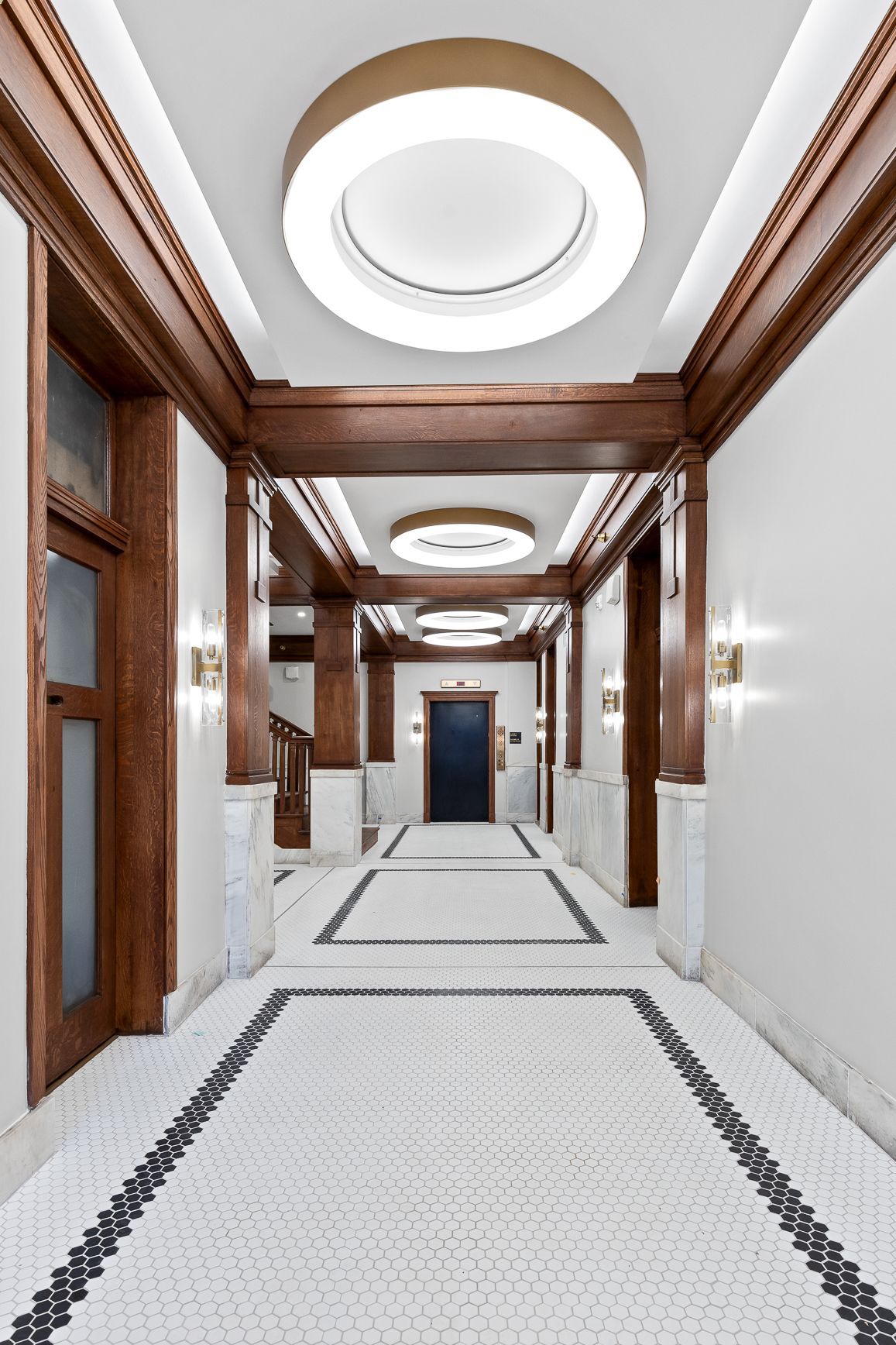 A long hallway with a tiled floor and a ceiling light.