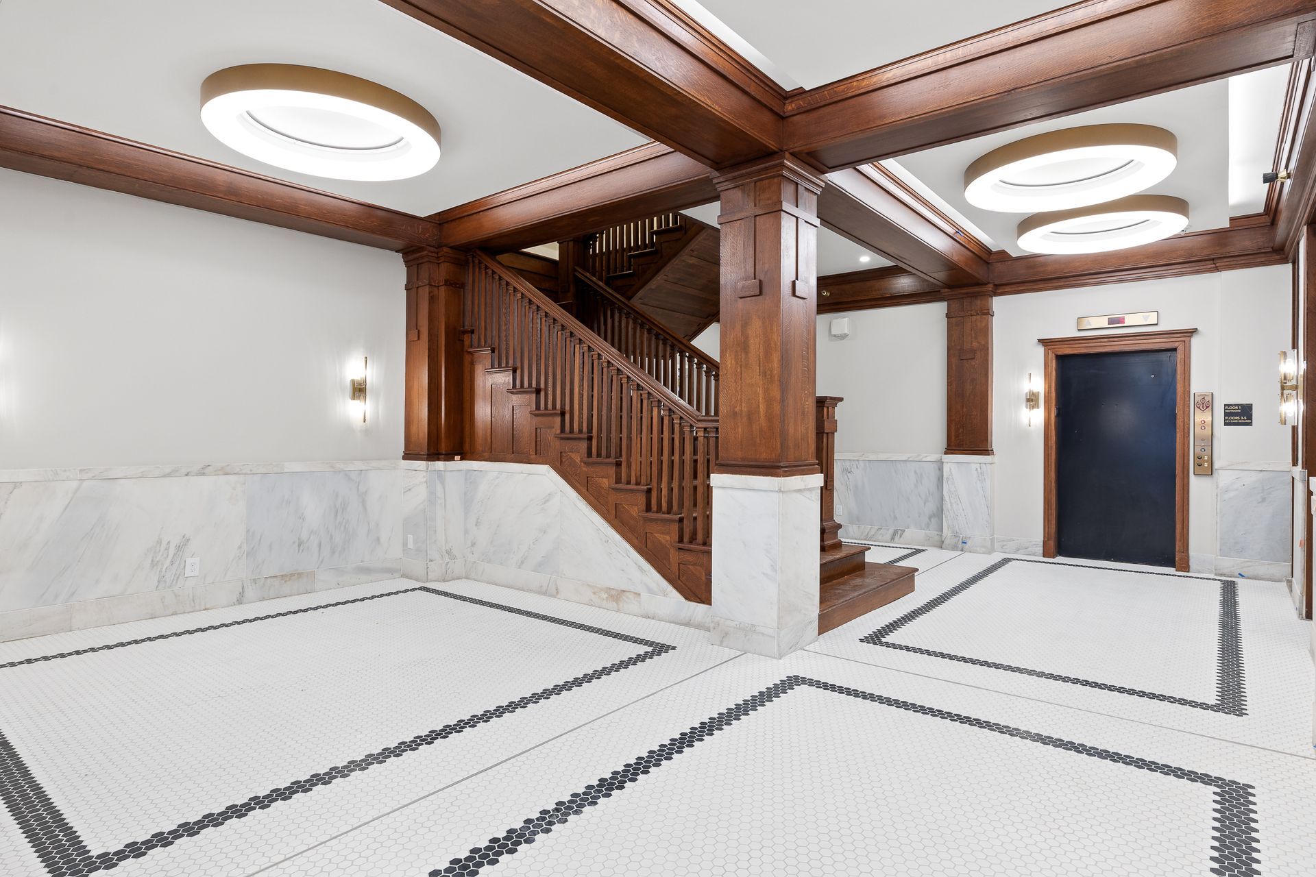 A large empty lobby with a staircase and elevator