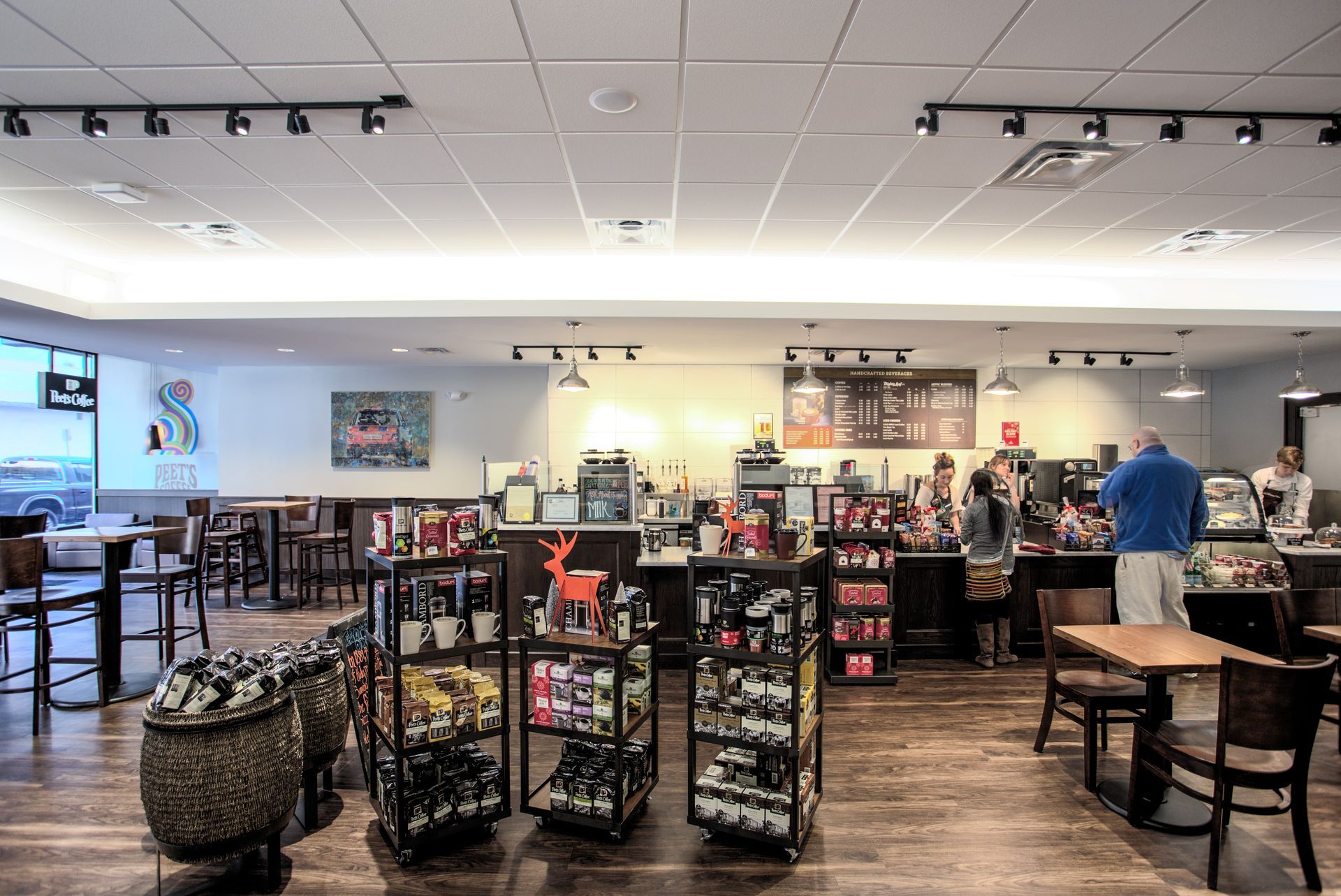 A large room with tables and chairs in a coffee shop.