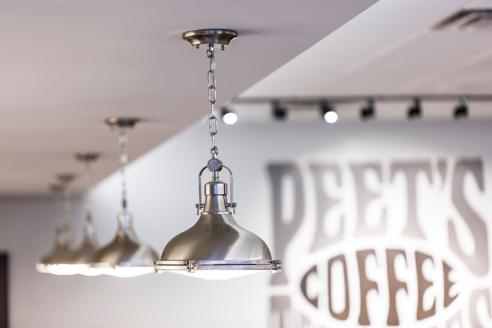 A sign that says deets coffee hangs from the ceiling