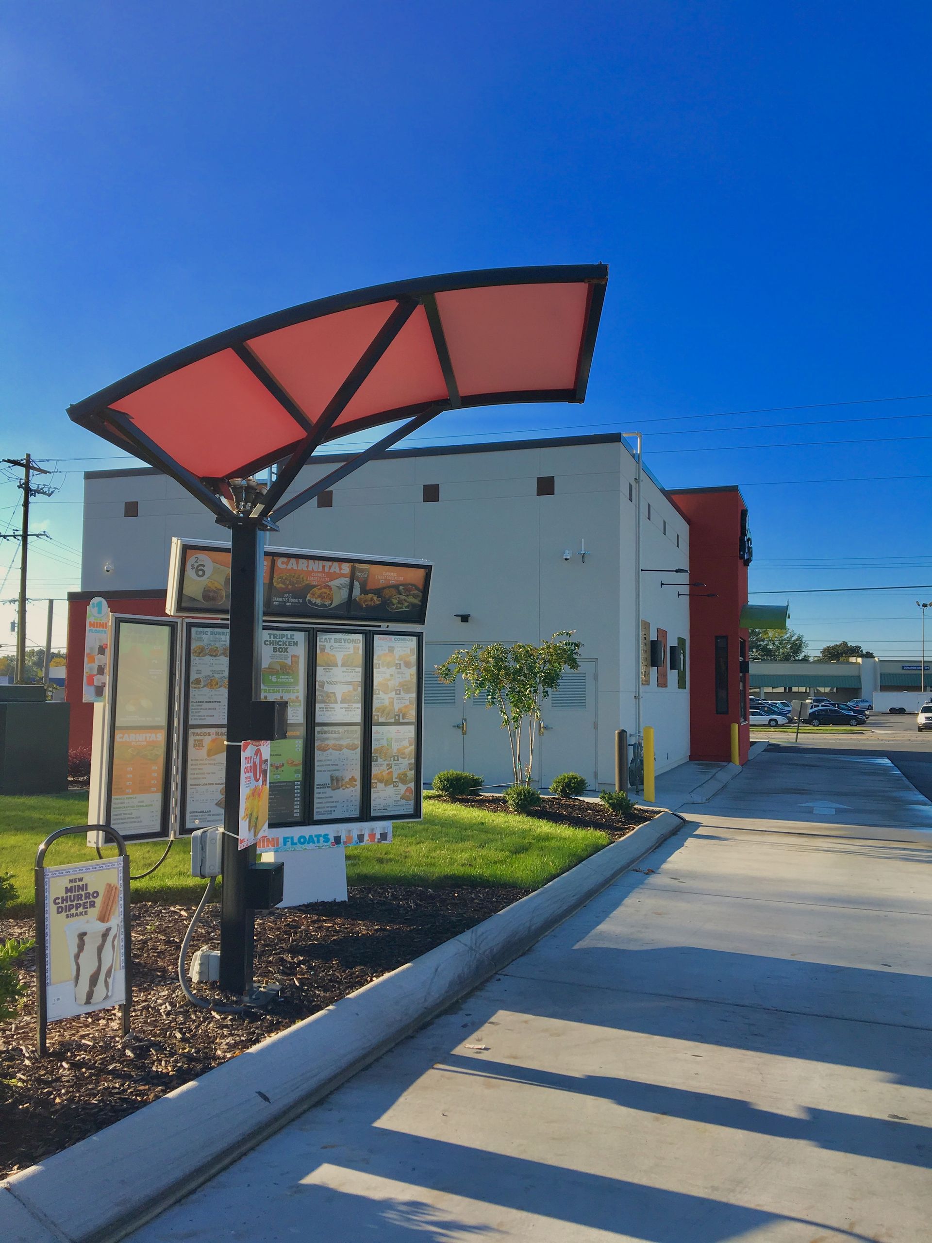 A drive thru at a fast food restaurant with a red umbrella