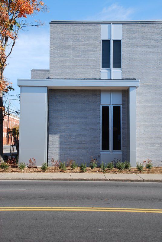 A building with a lot of windows is on the side of the road