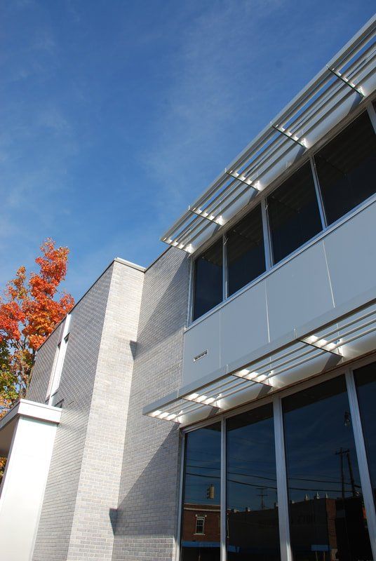A building with a lot of windows and a tree in the background
