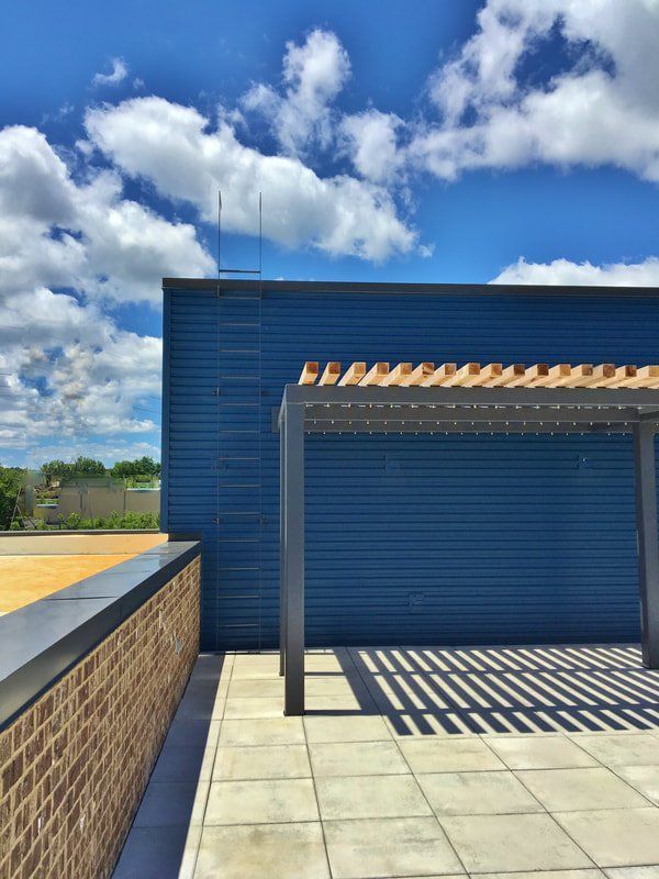 A blue building with a pergola on top of it