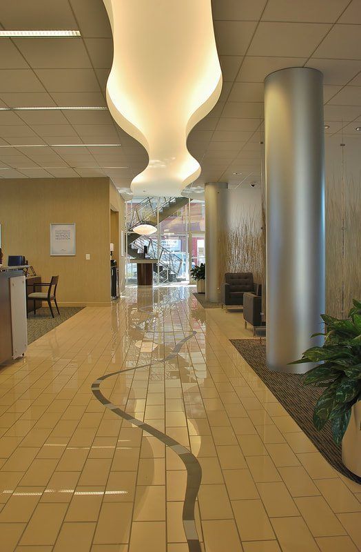A long hallway in a building with a ceiling light and a plant.