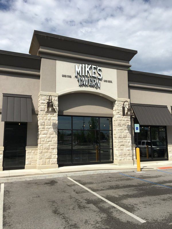 A mikes tavern building with a parking lot in front of it